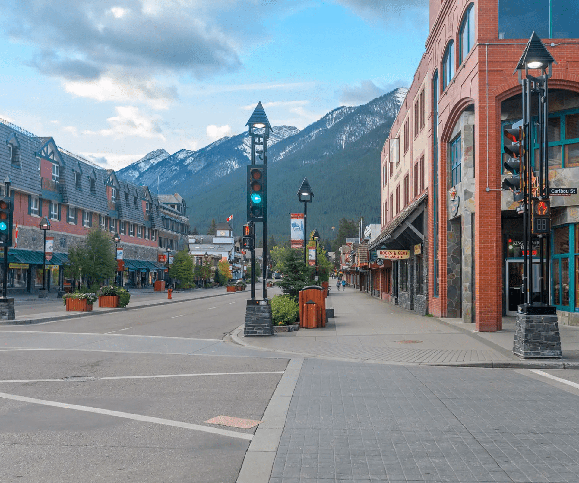 Mountain town street with buildings and traffic lights.